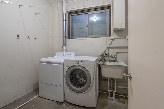 clothes washing area featuring separate washer and dryer and sink