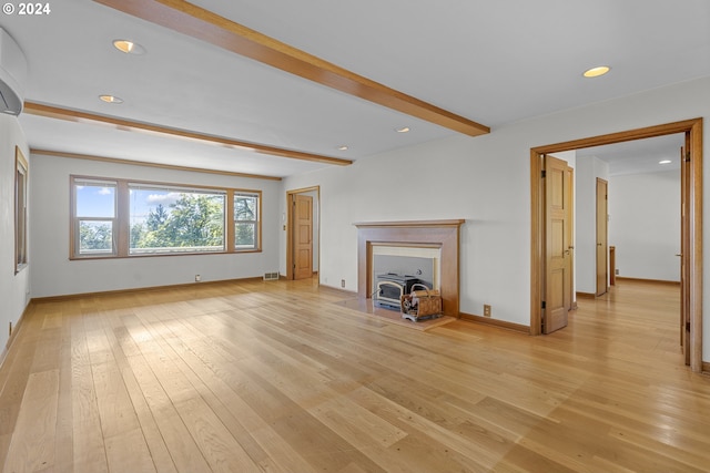 unfurnished living room featuring light wood-type flooring and beam ceiling