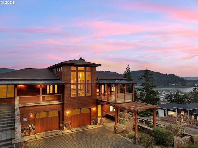 view of front of property with a mountain view, a garage, and a balcony