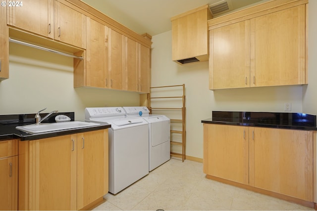 washroom with washer and clothes dryer, cabinets, and sink