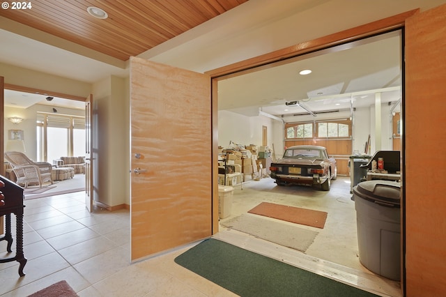 corridor featuring light tile patterned floors, plenty of natural light, and wood ceiling