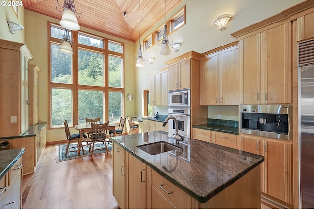 kitchen featuring sink, wooden ceiling, built in appliances, decorative light fixtures, and a center island with sink