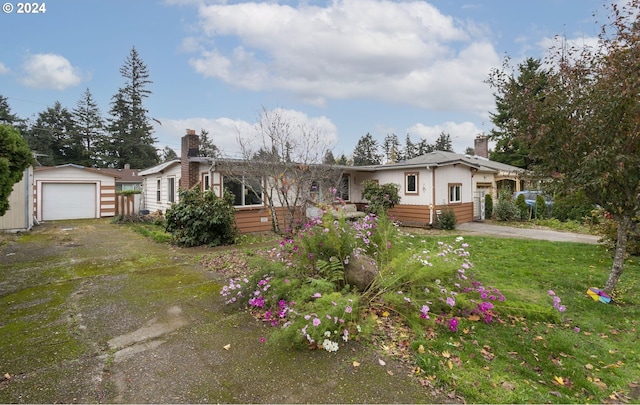 ranch-style house featuring an outbuilding, a garage, and a front lawn