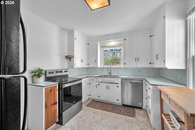 kitchen with appliances with stainless steel finishes, sink, and white cabinets