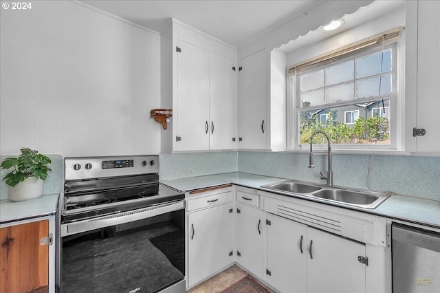 kitchen featuring stainless steel appliances, white cabinetry, sink, and backsplash