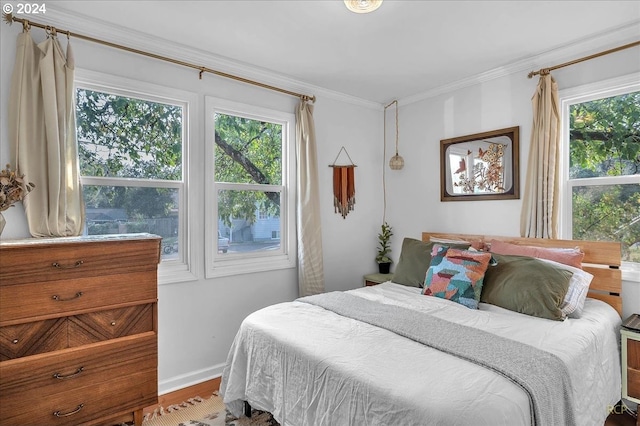 bedroom featuring hardwood / wood-style flooring, multiple windows, and crown molding