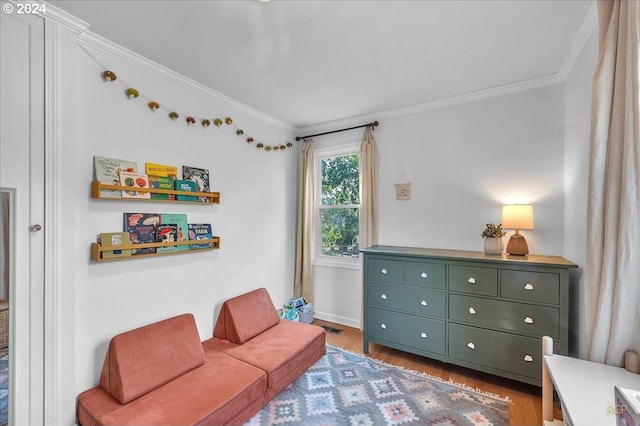 living area with light wood-type flooring and crown molding