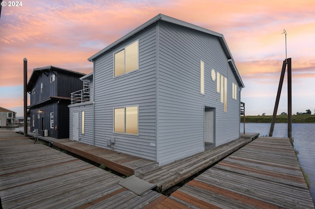 property exterior at dusk featuring a water view