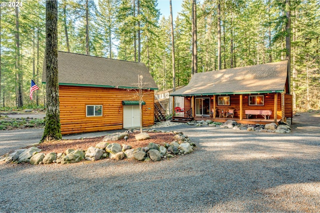 log-style house with a garage and a porch