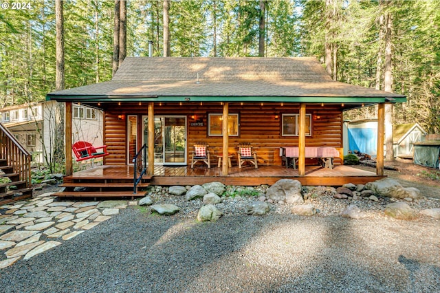 rear view of property featuring a wooden deck