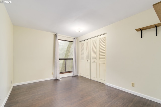 unfurnished bedroom with a closet and dark hardwood / wood-style floors