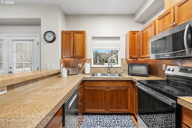 kitchen with decorative backsplash, appliances with stainless steel finishes, and sink