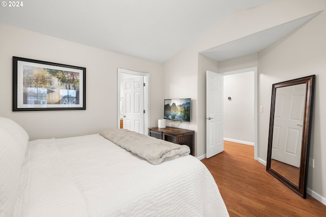 bedroom with wood-type flooring and lofted ceiling