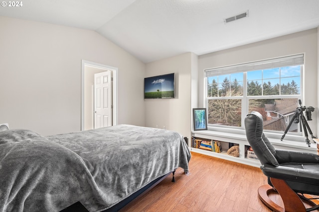 bedroom featuring hardwood / wood-style flooring and vaulted ceiling