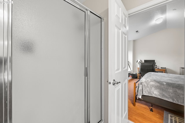 bedroom with wood-type flooring, a closet, and lofted ceiling