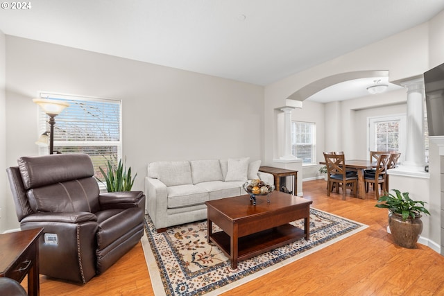 living room with light hardwood / wood-style flooring and decorative columns