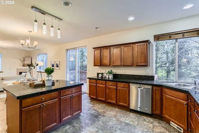 kitchen with sink, a center island, stainless steel dishwasher, a notable chandelier, and decorative light fixtures