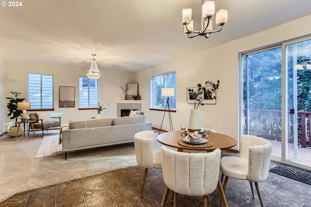 dining room with dark tile patterned flooring, a notable chandelier, and a healthy amount of sunlight