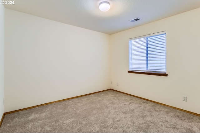 spare room featuring light colored carpet