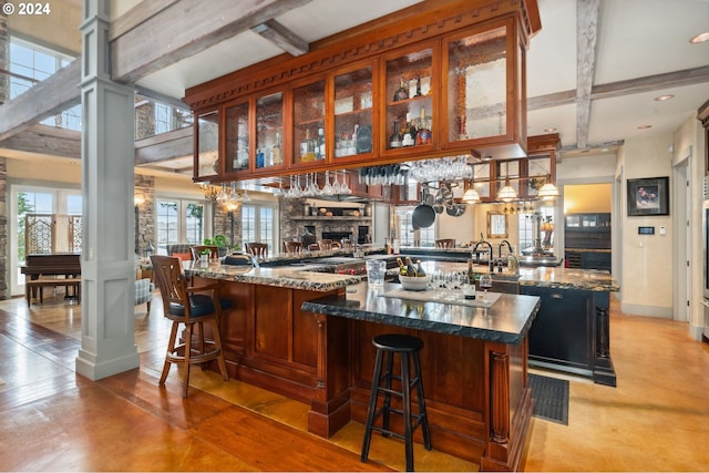 bar featuring dark stone countertops and beamed ceiling