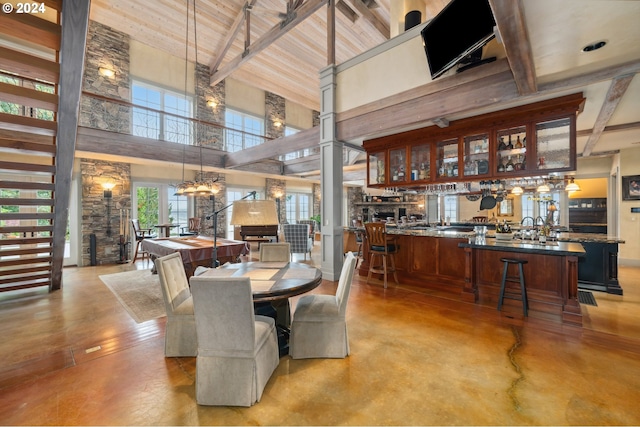 dining area with wood ceiling, bar area, beam ceiling, a fireplace, and high vaulted ceiling