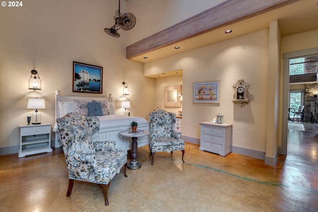 sitting room featuring concrete floors and a towering ceiling