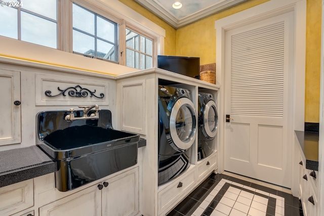 clothes washing area with dark tile patterned flooring, sink, washer and dryer, and crown molding