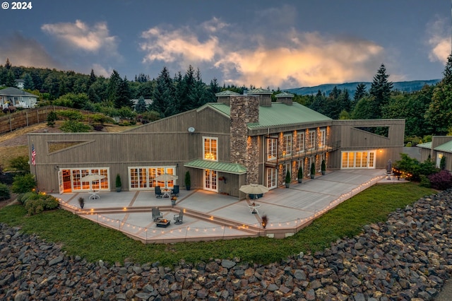 back house at dusk featuring a patio area and french doors