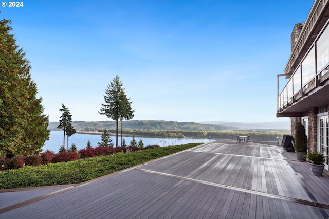 wooden terrace featuring a water and mountain view