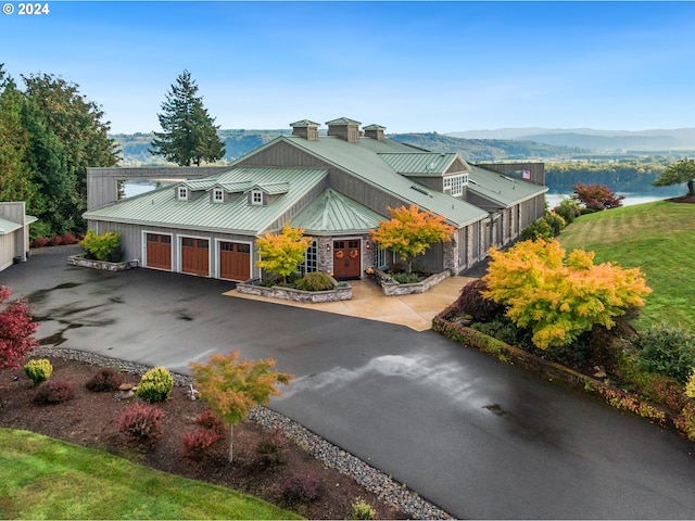 view of front facade with a front lawn, a water and mountain view, and a garage