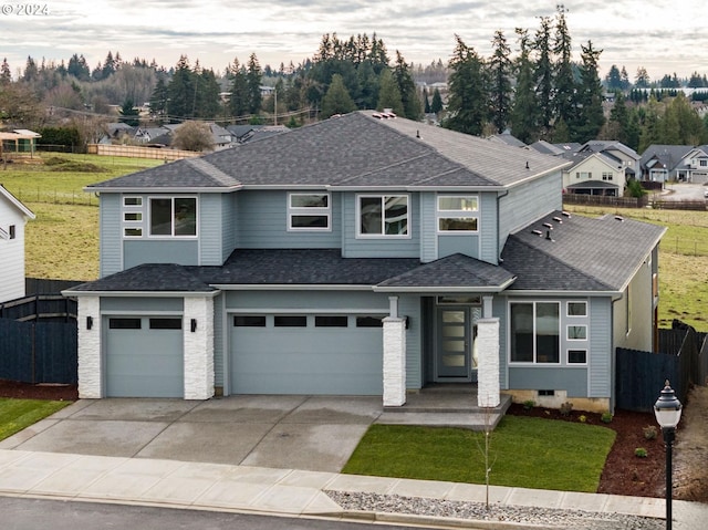 prairie-style house featuring a garage and a front lawn