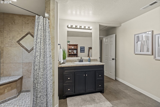 bathroom with a textured ceiling, vanity, and a shower with shower curtain