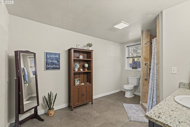 bathroom with a textured ceiling, toilet, vanity, and a shower with curtain