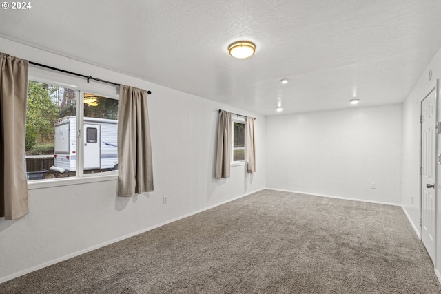 carpeted empty room with a textured ceiling