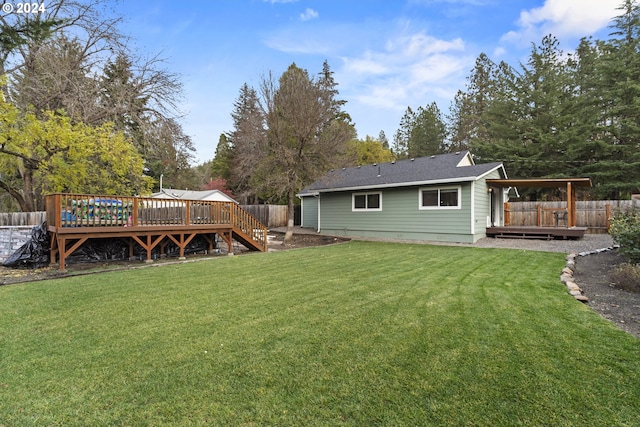 back of house with a wooden deck and a lawn