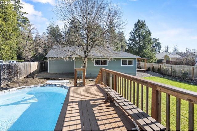 view of swimming pool with a wooden deck and a lawn