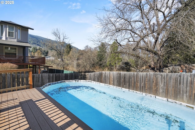 view of swimming pool featuring a deck with mountain view