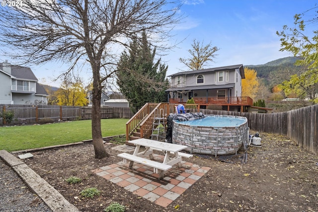 view of yard with a swimming pool side deck with mountain view