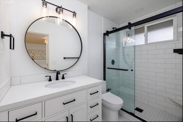 bathroom with walk in shower, vanity, and toilet