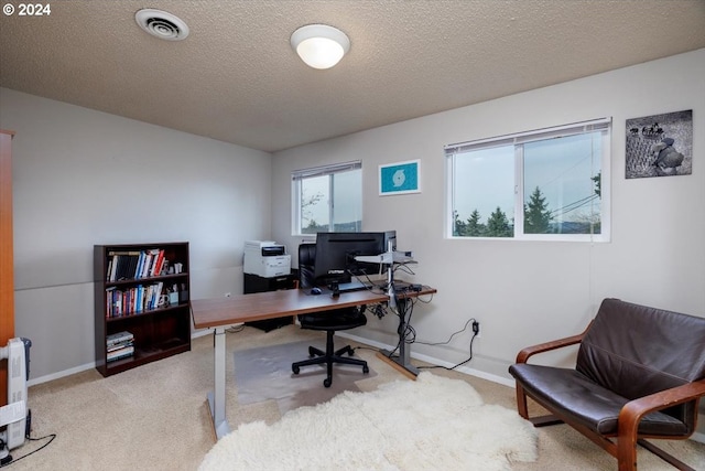 office space featuring carpet flooring, a textured ceiling, baseboards, and visible vents