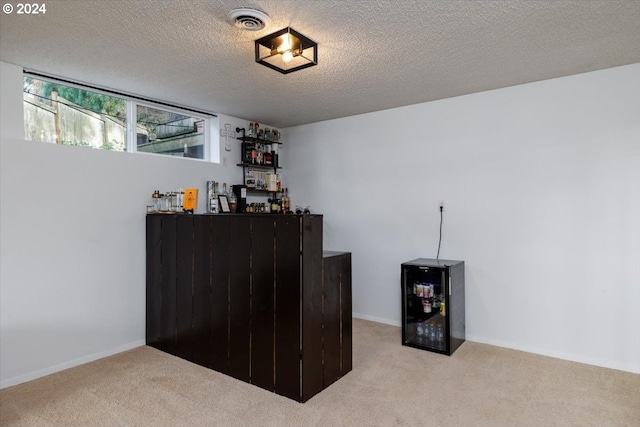 bar featuring visible vents, wine cooler, carpet, and a textured ceiling
