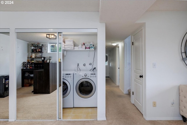 clothes washing area featuring light carpet, a textured ceiling, and independent washer and dryer