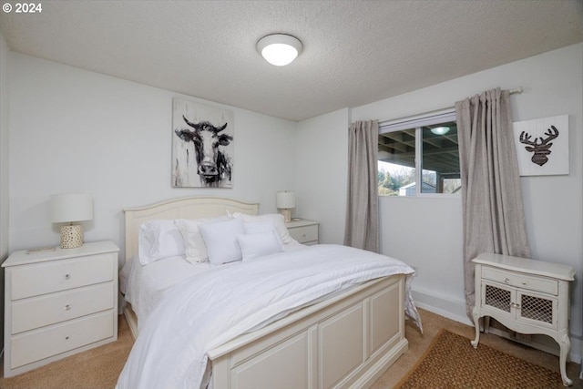 bedroom featuring a textured ceiling and light carpet