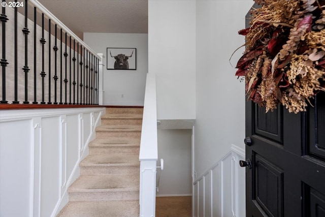 stairway featuring carpet and baseboards