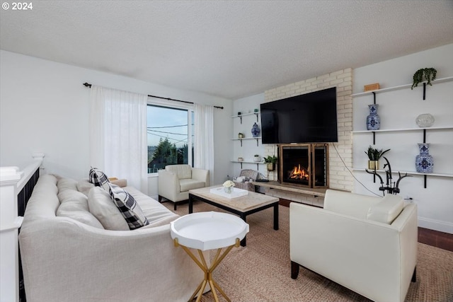 living area featuring a brick fireplace, wood finished floors, and a textured ceiling