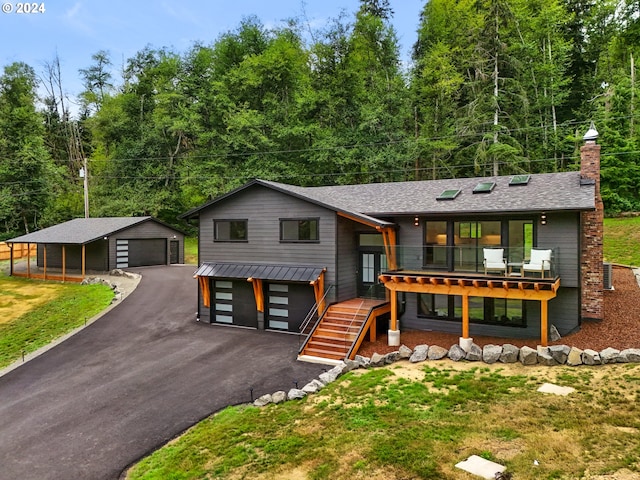 view of front of property with an outbuilding, a carport, a garage, and a front yard