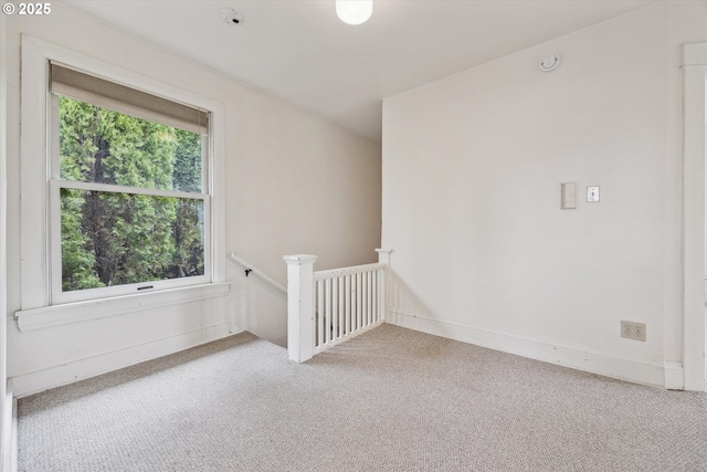 carpeted spare room featuring baseboards