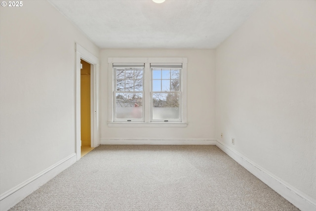 spare room featuring baseboards and carpet flooring