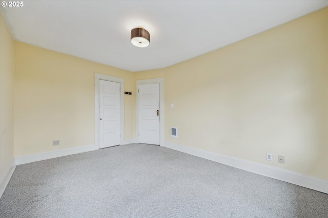 unfurnished room featuring visible vents, baseboards, and carpet