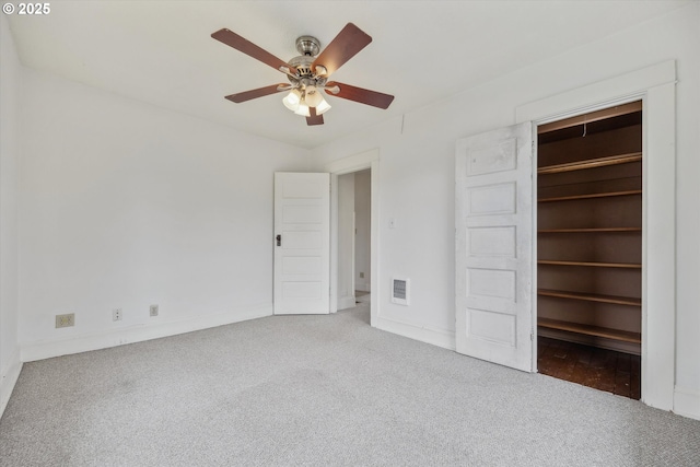 unfurnished bedroom featuring visible vents, a walk in closet, a ceiling fan, a closet, and carpet